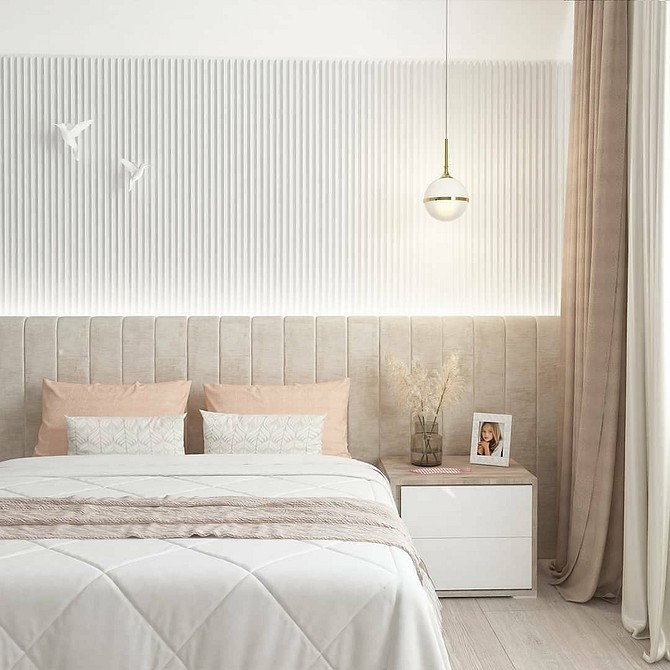 A modern bedroom with a white bed and beige walls.