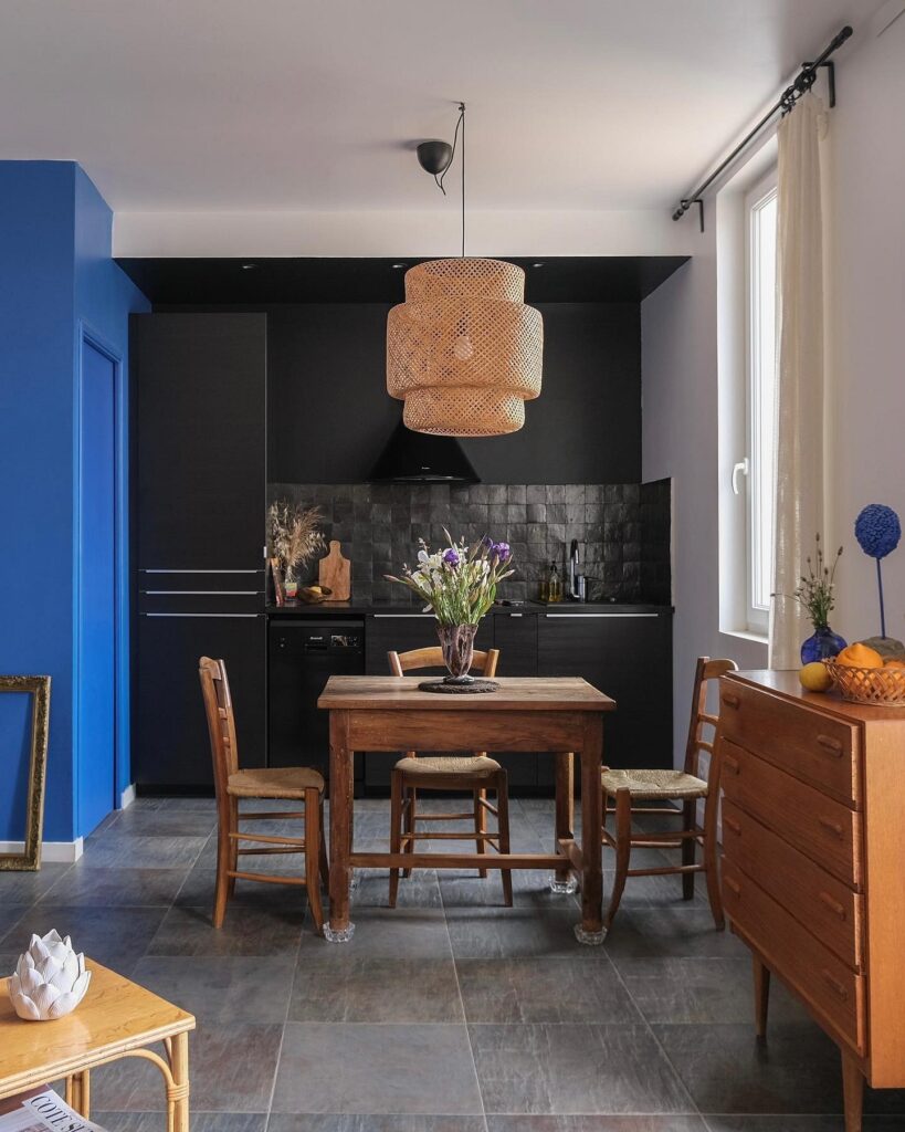A kitchen with blue walls and a wooden table.