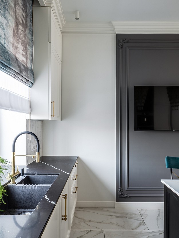 A black and white kitchen with a tv on the wall.