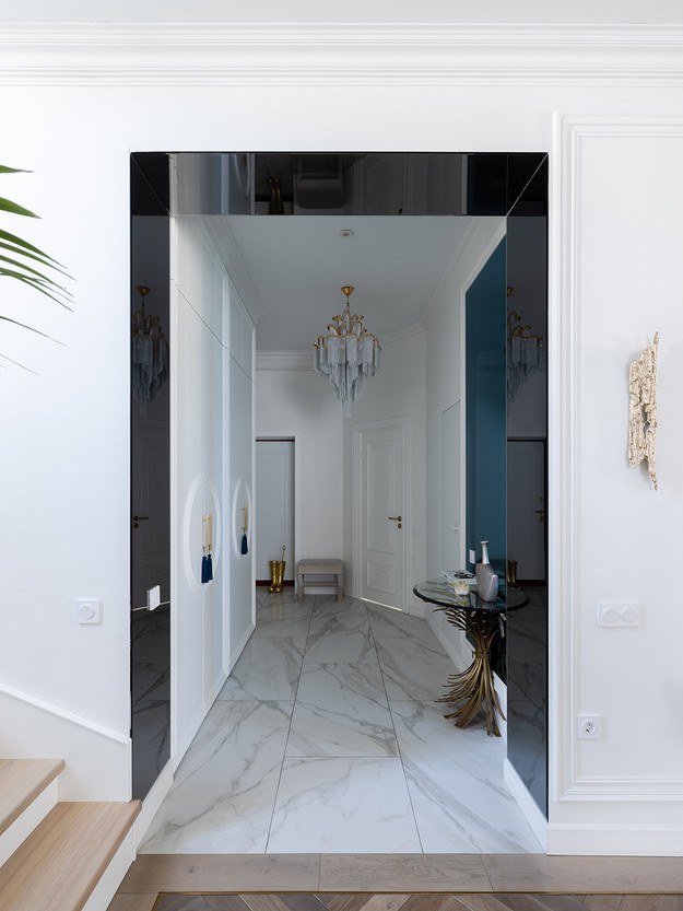 A hallway with a marble floor and white walls.