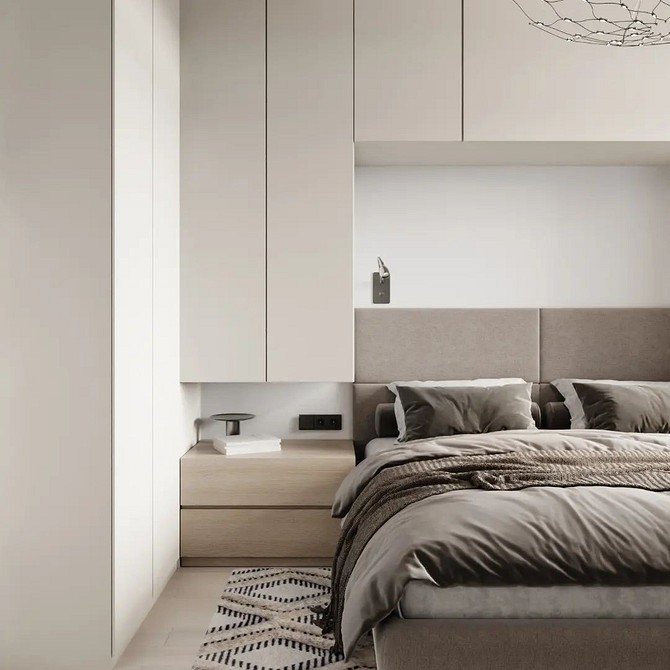 A modern bedroom with a white bed and beige walls.