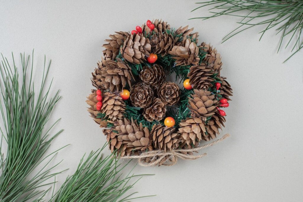 A pine cone wreath on a gray background.