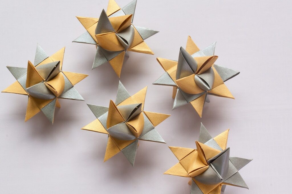 Five origami stars arranged on a white surface.