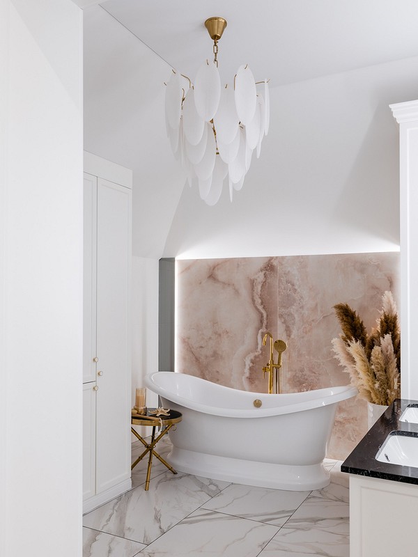 A white and gold bathroom with a marble bathtub.