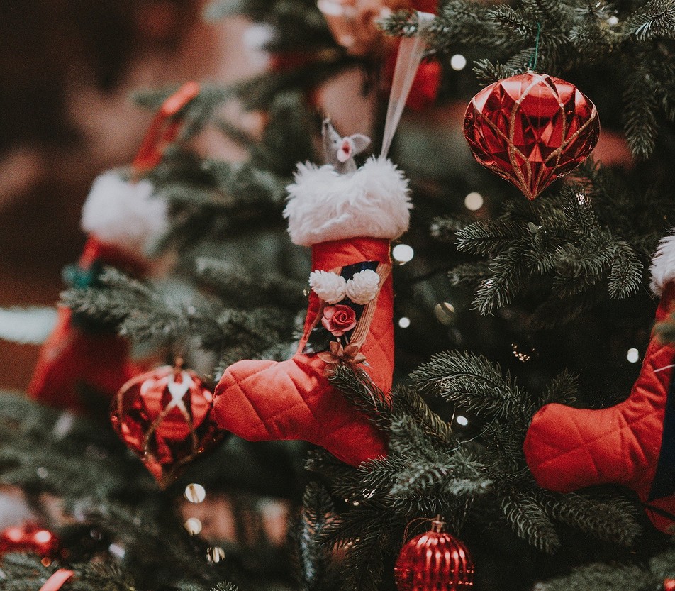 A christmas tree decorated with red stockings and ornaments.