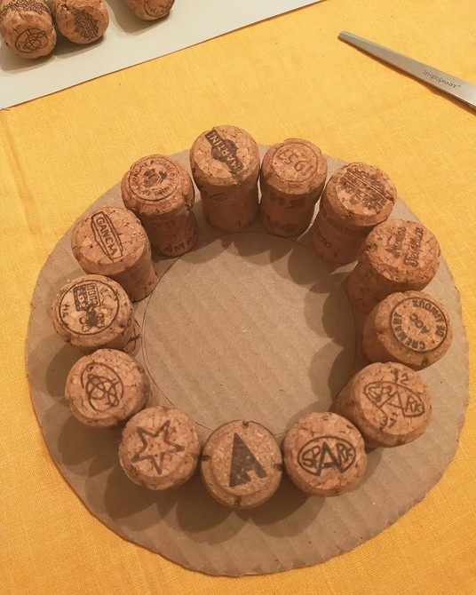 A circle of wine corks on a piece of paper.