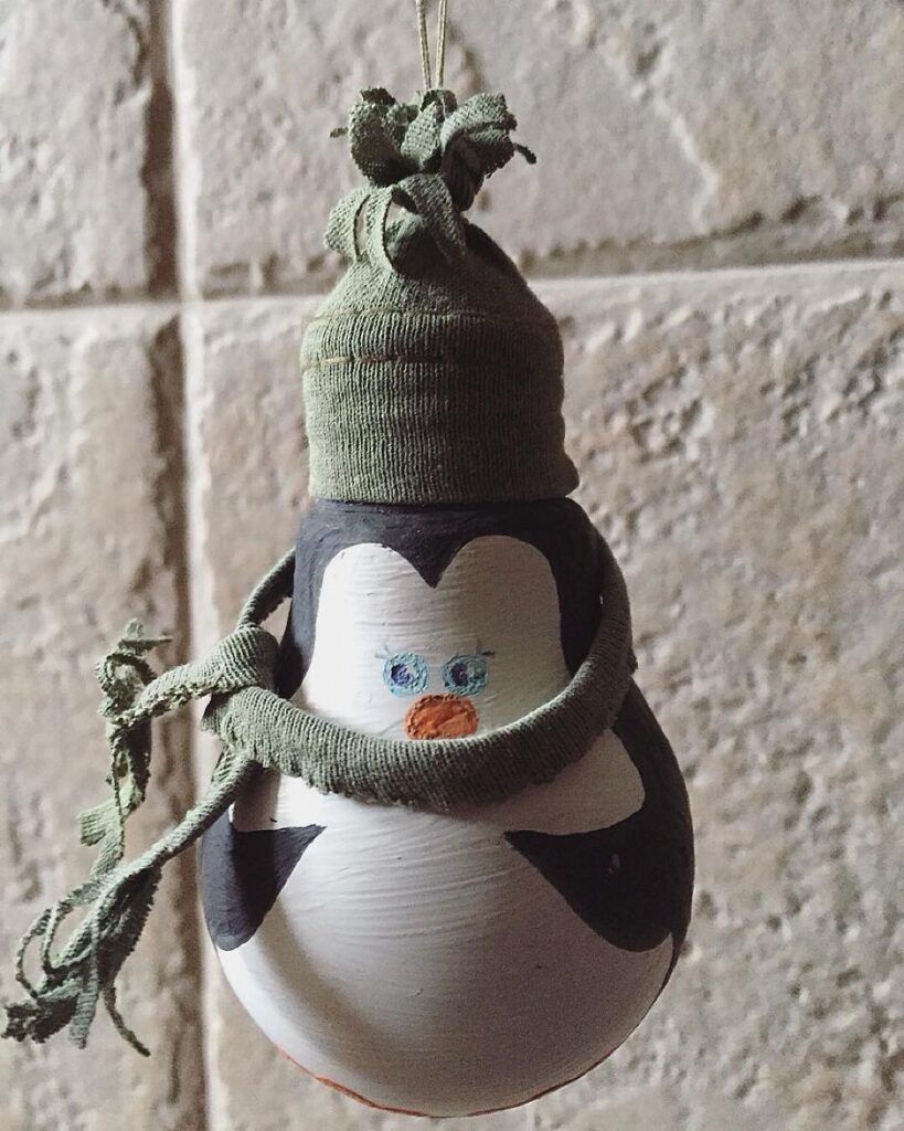 A penguin ornament hanging on a wall.