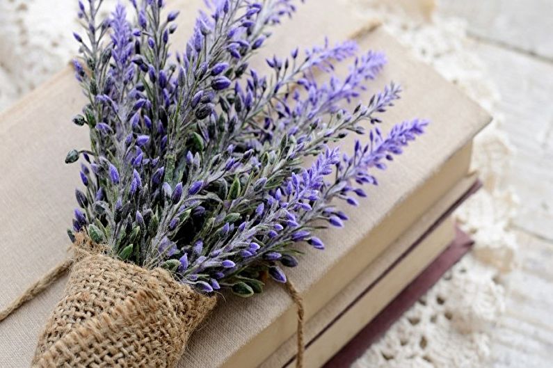 A bunch of lavender flowers on top of a stack of books.