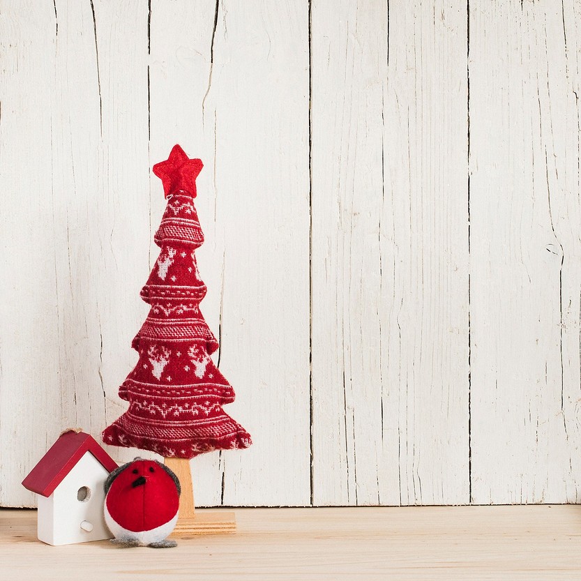 A christmas tree and ornaments on a wooden table.