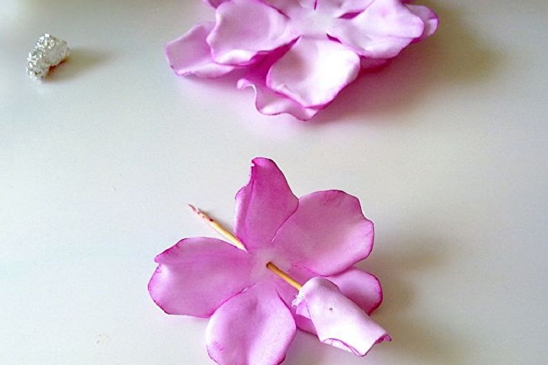 A pair of pink flowers on a white table.