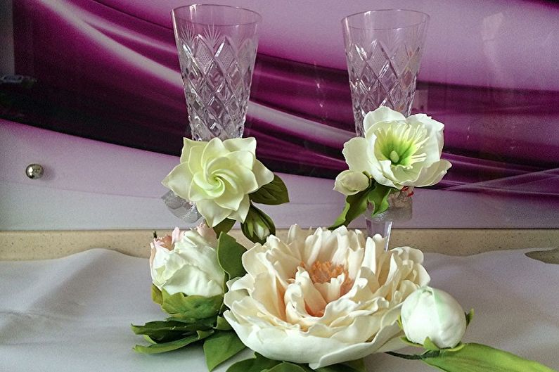 Two glasses with flowers in them on a table.