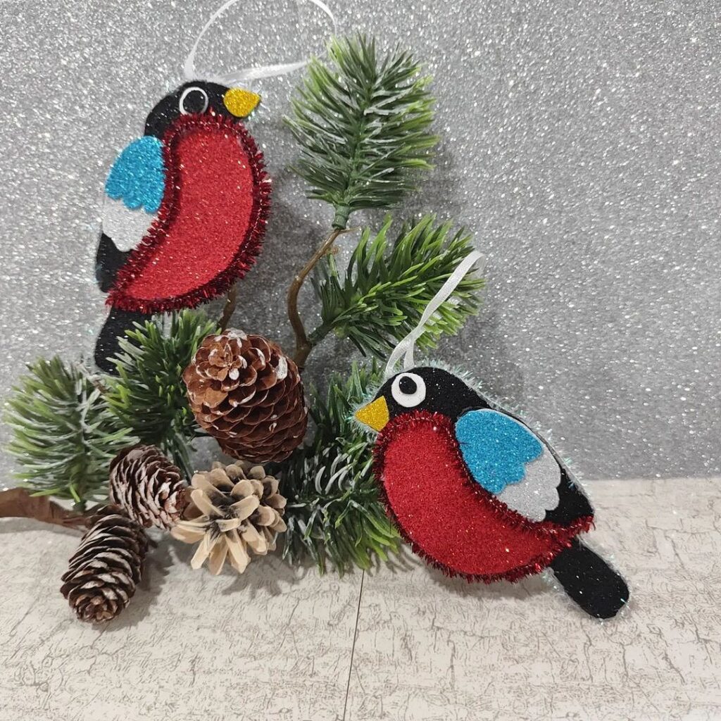 Two red and blue birds on a branch with pine cones.