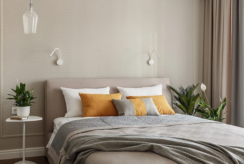 A modern bedroom with beige walls and yellow accents.