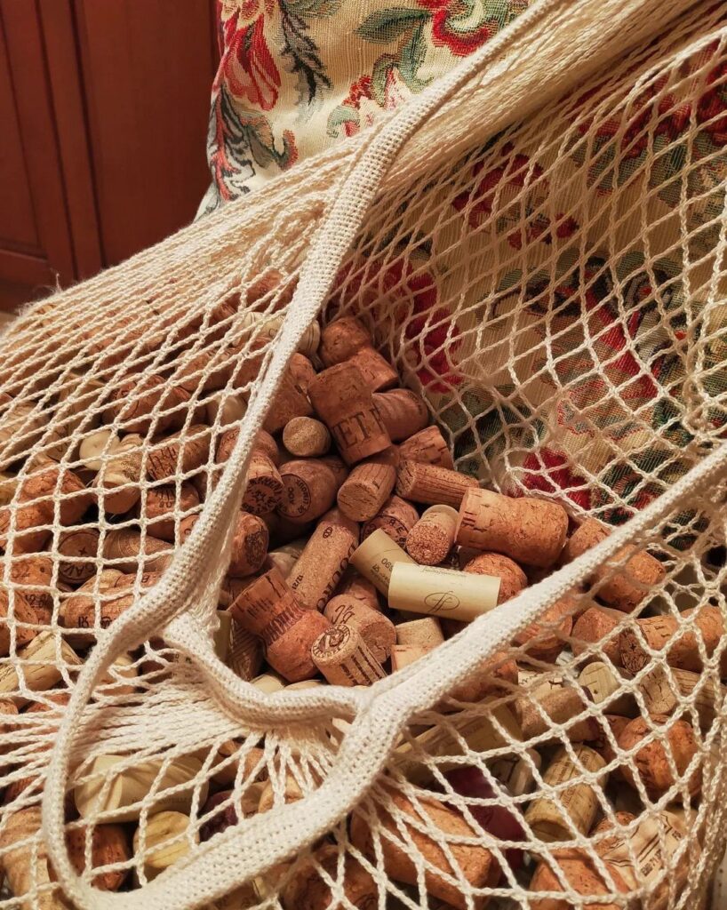 A bag filled with wine corks on a couch.