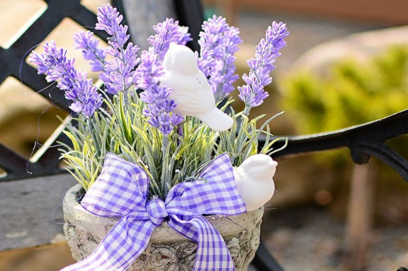 Lavender flowers in a pot on a wooden bench.