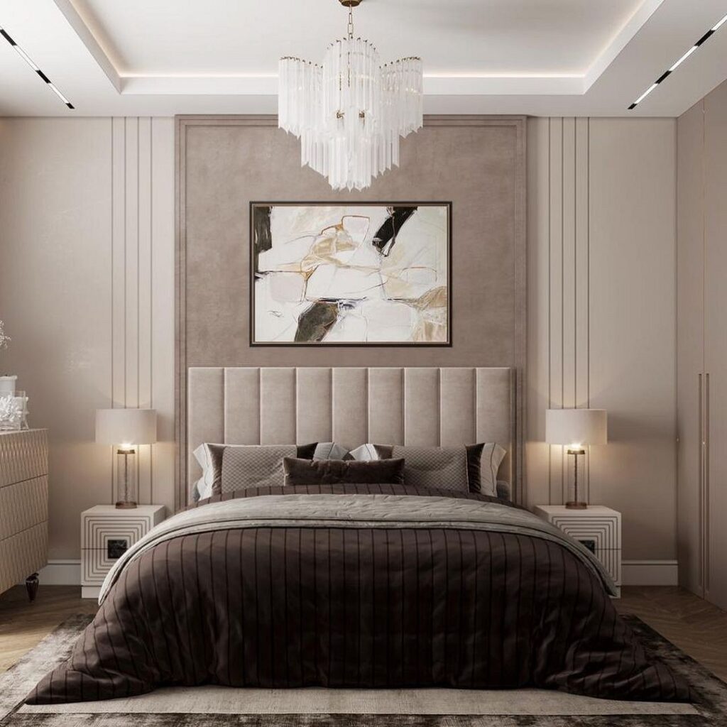 A modern bedroom with beige walls and a chandelier.