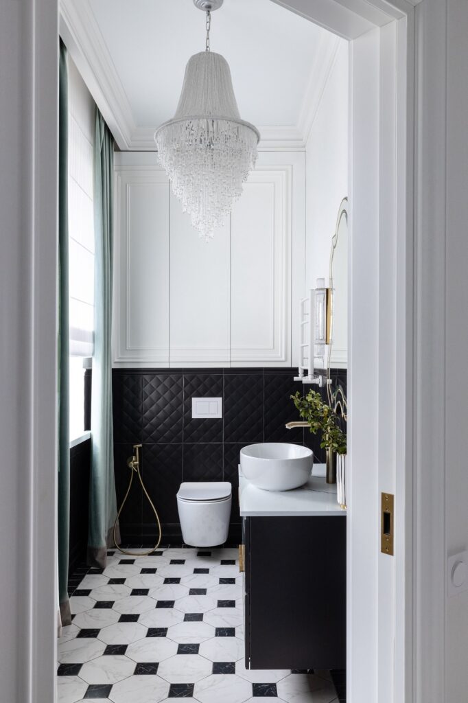 A black and white bathroom with a chandelier.