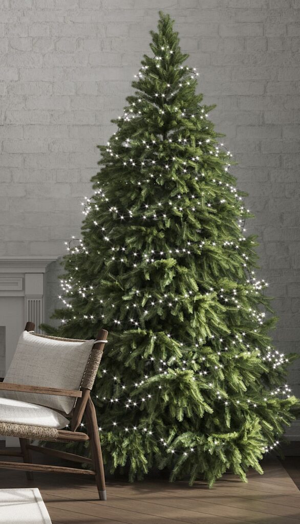 A christmas tree in a living room with a chair.