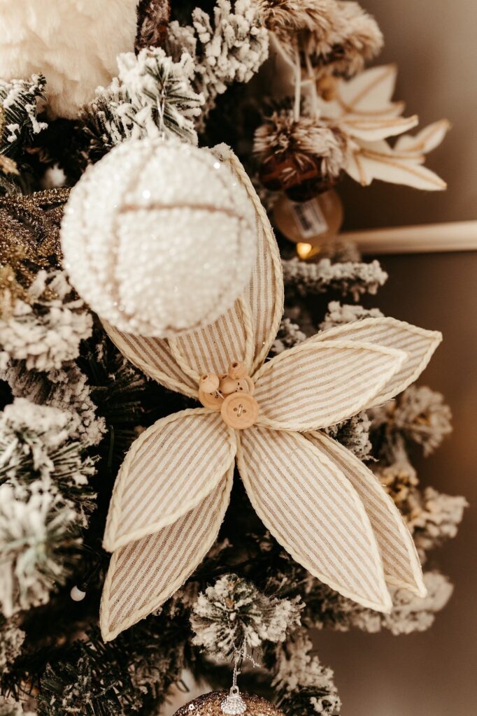 A christmas tree decorated with white and beige ornaments.