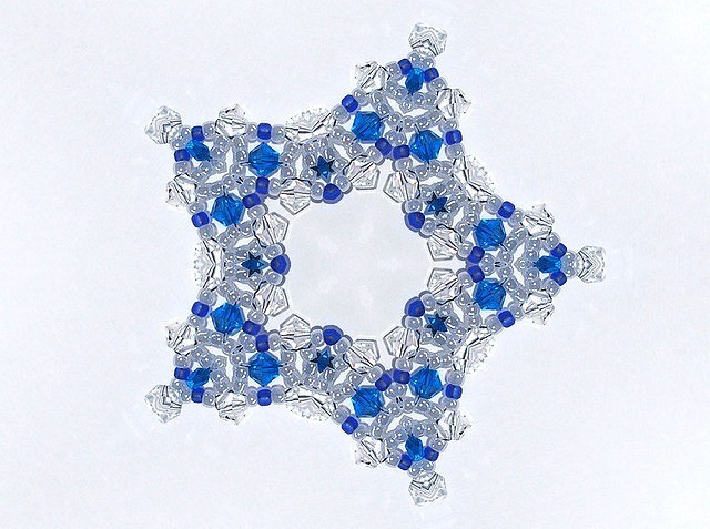 A blue and white snowflake on a white surface.