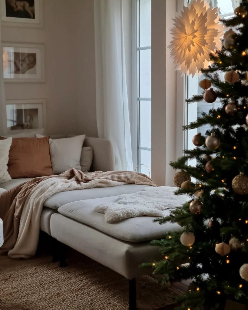 A living room with a christmas tree in front of it.