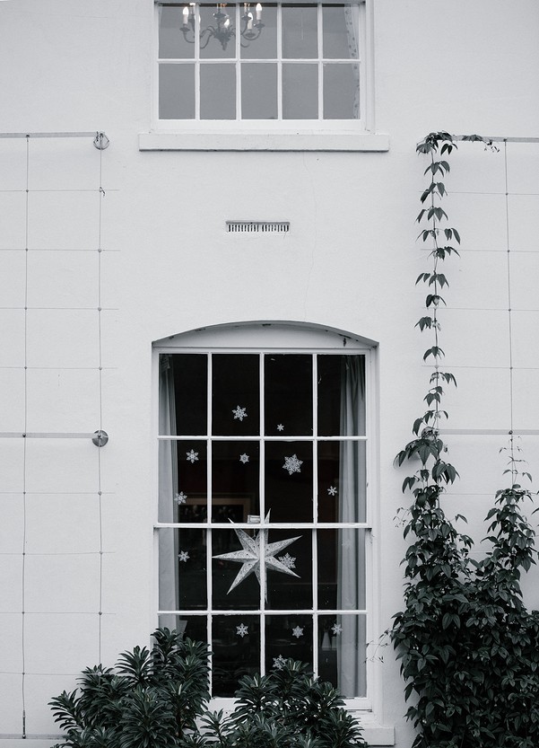 A black and white photo of a white house with a star in the window.