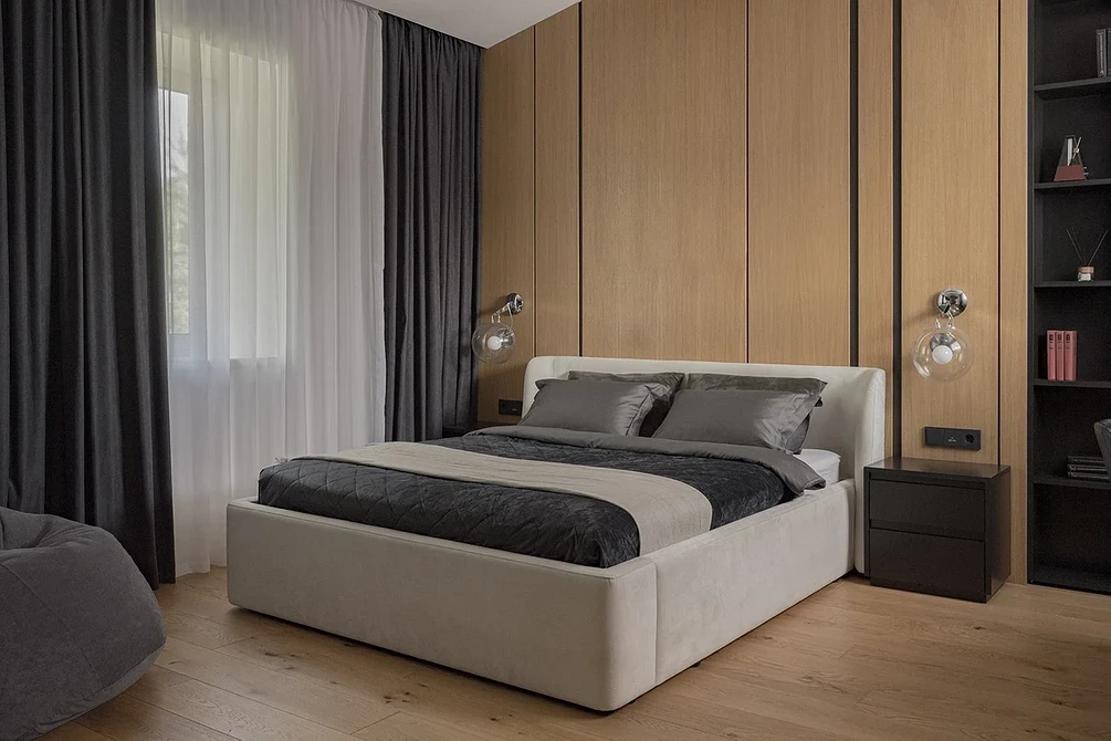 A modern bedroom with wood paneling and a bed.