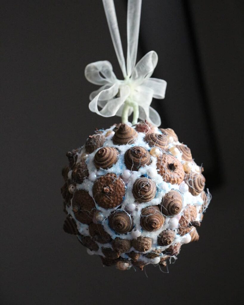 A blue and brown ornament hanging from a string.