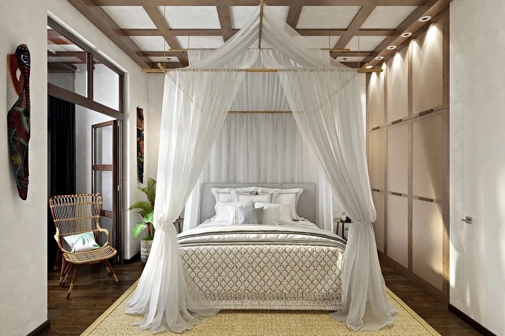 A bedroom with a white canopy bed and wooden floors.