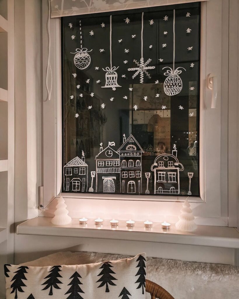 A black and white window with a christmas tree and candles.