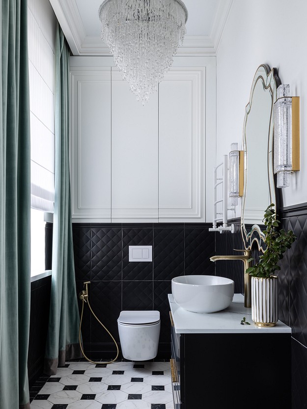 A black and white bathroom with a chandelier.