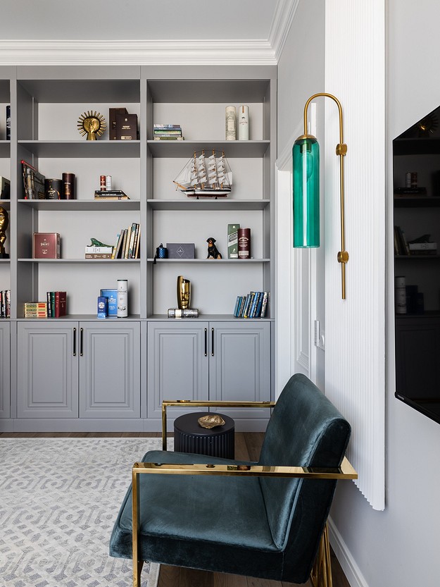 A living room with bookshelves and a green chair.