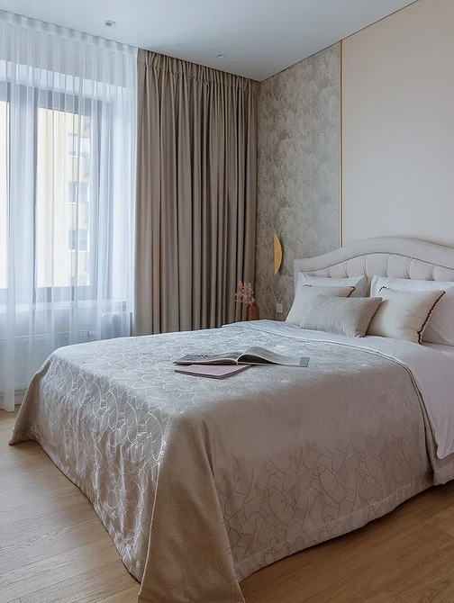 A bedroom with beige walls and a white bed.