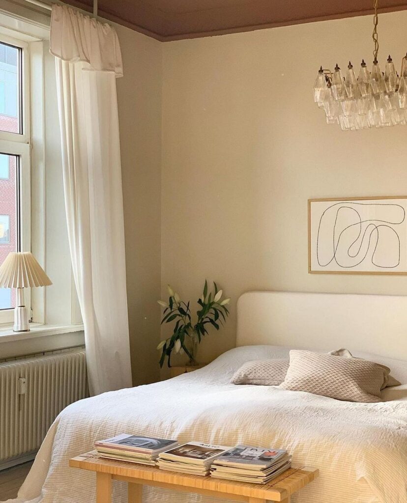 A bedroom with a white bed and a chandelier.