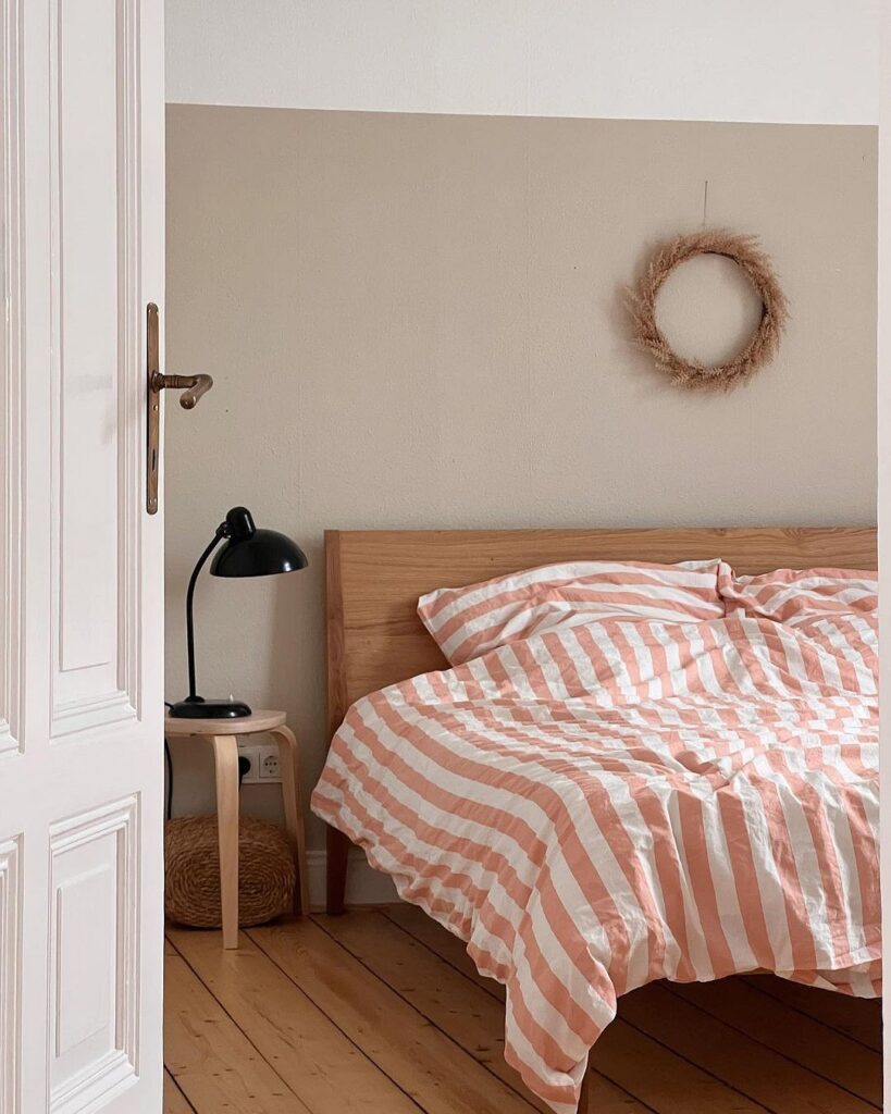 A bedroom with a pink and white striped duvet.