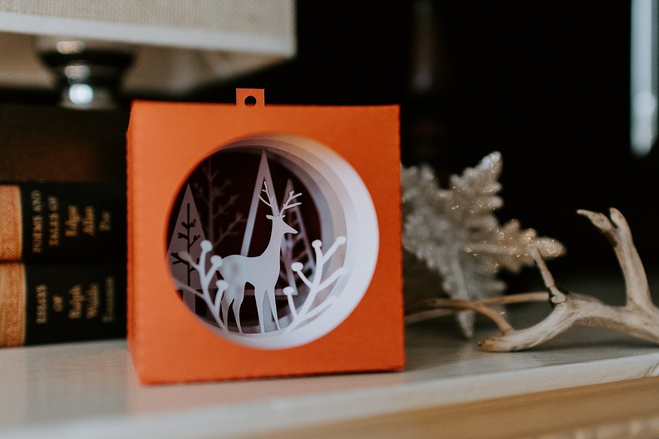 A paper cut out of a deer sitting on a mantle.