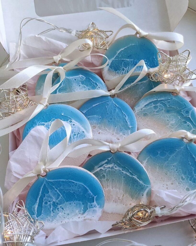 A box of cookies decorated with blue and white sand.