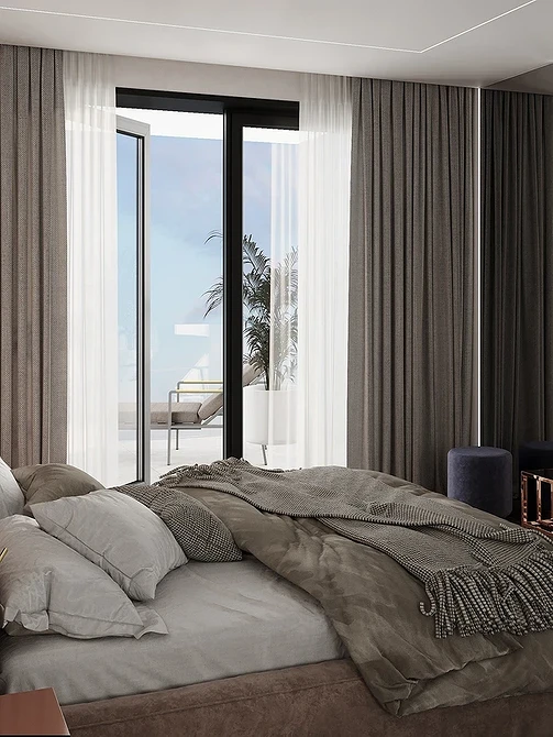 A bedroom with a large bed and a view of the ocean.